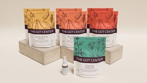 Renew Core set on a plaster block: Radiant Morning and Reviving Daily Kitchari pouches, Clarifying Herbal Tea and a Lightening Hydration Drops bottle.